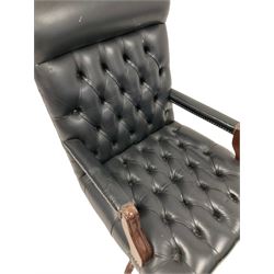 Mahogany swivelling and adjustable desk chair, upholstered in buttoned black leather 