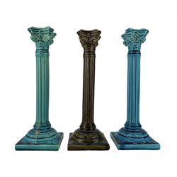 Pair of Burmantofts turquoise-glaze corinthian column candlesticks, H29cm and another in an olive green glaze, all having impressed factory marks beneath, model no. 1198 (3)