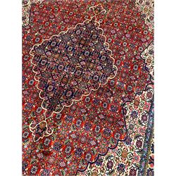 Persian Herati red ground rug, the cusped medallion and field borders decorated with repeating Herati motifs, multi-band border decorated with repeating stylised flower head motifs and geometric patterns