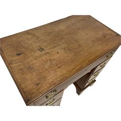 George II red walnut kneehole desk, moulded rectangular top over slide, fitted with one long drawer, six short drawers and central shallow drawer over cupboard, with shaped and pierced handles plates, on bracket feet