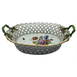 Large Meissen porcelain oval fruit basket, with two naturalistic entwined handles, terminating with encrusted flowers and foliage, the interior hand painted with floral sprays and insects, the exterior painted with blue flower heads, crossed swords mark beneath (a/f) L40cm 