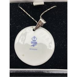 Anton Michelsen for Royal Copenhagen, a circular porcelain pendant designed by Nils Thorsson with silver mount stamped 925 D3.5cm together with a Royal Copenhagen porcelain pendant in the form of a Butterfly on silver choker stamped 925S (2)