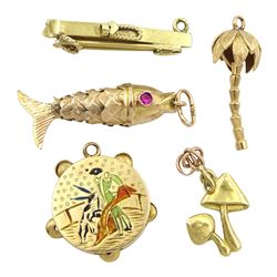Three 18ct gold charms including tambourine with matador scene, mushroom and palm tree and two 14ct gold charms including an articulated fish with stone set eyes 
