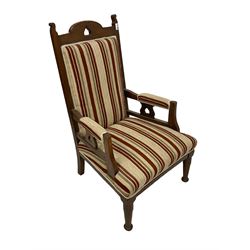 Arts & Crafts period oak armchair, the cresting rail and arm splats pierced with heart motifs, upholstered in striped fabric, on turned supports