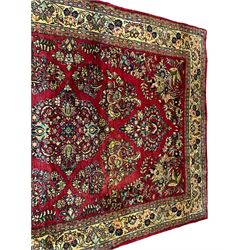 Persian Kerman crimson ground rug, the central floral lozenge surrounded by bouquets of flowers with golden outlines, the matching spandrels with additional leaf motifs, the gold border with repeating stylised palmettes united by scrolling branches