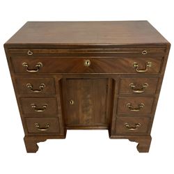 George III mahogany kneehole desk or dressing table, moulded rectangular top over slide with baize lining, single long drawer, six short drawers and cupboard, the drawers and cupboard door with cock-beading, on bracket feet