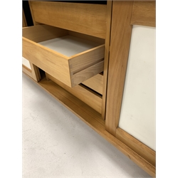 Mid to late 20th century beech and white laminate sideboard, three sliding doors enclosing shelves and drawers, raised on square supports 