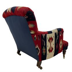 Howard & Sons Ltd - late 19th century easy armchair, upholstered in kilim fabric with sprung back and seat, raised on ring turned tapering supports with brass cups and castors, the rear leg stamped '12332 9522 Howard & Sons Ltd Berners Street', each castor stamped 'Howard & Sons Ltd London'
