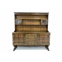 20th century oak dresser, two height plate rack with carved frieze and two lead glazed doors, over four drawers to centre and two cupboard W165cm, H171cm, D47cm