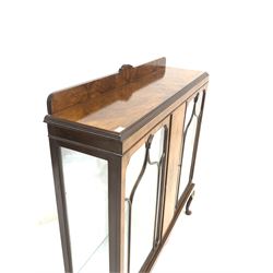 Early 20th century figured walnut display cabinet, the raised back over two tracery glazed doors enclosing two glass shelves, raised on shell carved cabriole supports W122cm, H133cm, D34cm