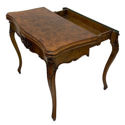 Victorian figured walnut games table, shaped and moulded fold-over top with quarter matched veneers, the sunken interior fitted with baize playing surface, pull-out action base revealing storage compartment, the frieze rail mounted by carved rose with foliage and extending flower heads, on leaf carved and moulded cabriole supports