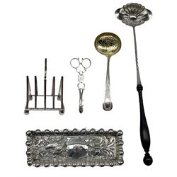 George III parcel gilt silver sifting spoon with engraved decoration London 1810 Makers Peter and William Bateman, embossed silver dressing table tray Chester 1903, pair of silver scissor action sugar tongs, Art Deco design four division silver toast rack London 1912 Maker Robert Stewart and a French plated Alfenide toddy ladle by Charles Helphen, Paris, silver weight 6.4oz