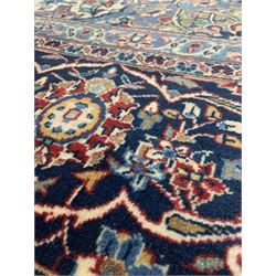 Persian hand knotted Tabriz ground carpet, red field centred by a deep blue medallion and decorated with trailing foliate, signed to border 320cm x 520cm