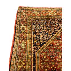 Persian Herati red ground rug, extended lozenge field with central medallion, surround by repeating Herati motifs, the main border decorated with stylised plant motifs
