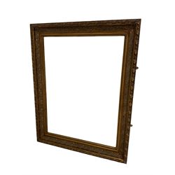 Large wall mirror in heavy swept gilt frame with floral swags, bevelled plate