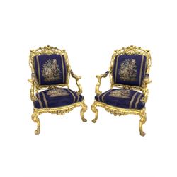 Pair of 18th century design giltwood throne chairs, profusely carved with foliate, acanthus leaves and scrolls, back, seat and arms upholstered in royal blue velvet with a floral needlework design, 