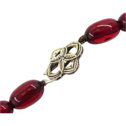 Graduated red bakelite oval bead necklace on a fancy rose cut diamond set clasp stamped 9ct
