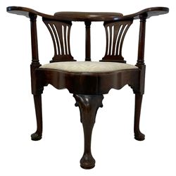 George III carved mahogany elbow chair, curved cresting rail terminating to swept arm rests, supported by columns and pierced splats, the drop-in seat upholstered in contemporary patterned ivory fabric, shaped apron on scroll topped cabriole front support with pad feet