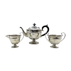 Silver three piece tea set of circular design, the teapot with black handle and lift London 1932 Maker Sir John Bennett Ltd 20oz gross
