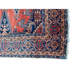 Persian Wiss red ground rug, triple medallions decorated with stylised flower head motifs, plain field with lozenge panels and spandrels decorated with Boteh and tree of life motifs, the main border decorated with repeating flower heads within multiple guard stripes