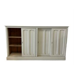 Painted side cabinet, the projecting rectangular top over four sliding doors, opening to reveal two fixed shelves, raised on a plinth base