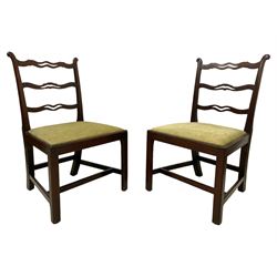 Pair of George III mahogany side chairs, eared uprights rails with pierced waved ladder back, drop-in seats upholstered in green fabric, on moulded square supports with inner chamfer united by H-stretchers 
Provenance: From the Estate of the late Dowager Lady St Oswald