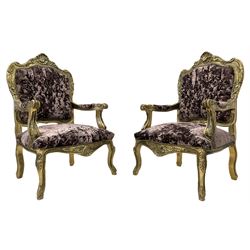 Pair late 20th century French style giltwood armchairs, the shaped back decorated with shell and flower heads, scrolled arm terminals, upholstered in buttoned purple crushed velvet, shaped apron carved with flower beads, cabriole supports 