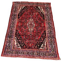 Persian design wool thick pile ground rug, red field with Geometric lozenge medallion and spandrels, double guarded border 296cm x 207cm