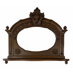 20th century oak framed wall mirror, surmounted by cartouche pediment with floral scrolls, oak leaves carved in relief, oval bevelled plate, open shelf, 68cm x 57cm