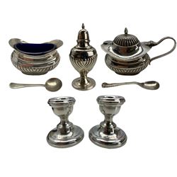 Silver three piece condiment set with half body decoration Birmingham 1965, cased and a pair of silver dressing table candlesticks H7cm
