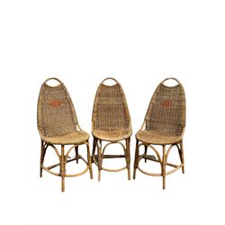Set of three mid century wicker chairs raised on bamboo supports 