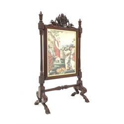 Victorian mahogany fire screen, reeded frame with needlework panel surmounted by floral carved pediment, raised on four hoof carved supports 