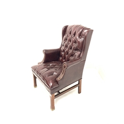 20th century George III style wing back armchair, upholstered in deep buttoned and studded ox blood leather, raised on square chamfered supports 