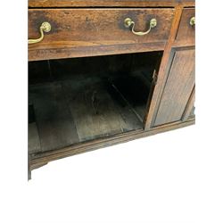 Georgian oak dresser, the two height plate rack fitted with hooks over base fitted with one small drawer, flanked by two long drawers over two cupboard doors, raised on bracket supports 
