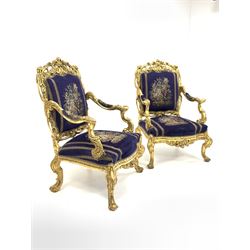 Pair of 18th century design giltwood throne chairs, profusely carved with foliate, acanthus leaves and scrolls, back, seat and arms upholstered in royal blue velvet with a floral needlework design, 