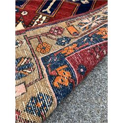 Persian Heriz runner rug, the central red field with three geometric medallions, enclosed by multi line border 300cm x 100cm