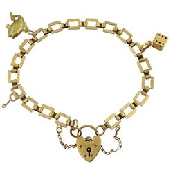 9ct gold bracelet with heart locket clasp and a 9ct gold fish charm and an 18ct gold dice charm, hallmarked or tested