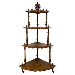 Victorian figured walnut corner whatnot, fretwork pediment over four graduating tires, on turned and lobe carved supports, inlaid with boxwood stringing and trailing foliate decoration, turned feet on brass and ceramic castors 