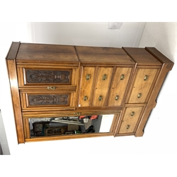 Late Victorian wardrobe, double urn carved cupboard enclosing two fixed shelves above three graduating drawers and flanked by a bevel edged mirrored door enclosing interior fitted for hanging, two drawers under, shaped plinth base 