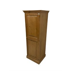 Waxed pine cupboard, fitted with single door, opening to reveal one fixed shelf over one hanging rail, raised on a plinth base
