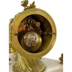 French white marble and gilt-metal striking portico mantel clock and garniture, circa 1910, with four free-standing columns above a shaped plinth base on four feet, gilt metal drum case surmounted by two small nesting birds, convex enamel dial with floral garlands and Arabic numerals, gilt Louis XV hands and minute markers, 8-day outside countwheel striking movement striking the hours and half hours on a bell, with a sunburst pendulum and matching pair of garniture urns with conforming decoration.