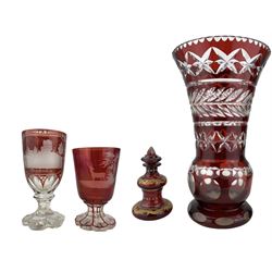 19th century Bohemian ruby overaly glass goblet, the funnel bowl engraved with a Stag in a woodland landscape, on faceted foot H13.5cm, a similar goblet engraved with views of German castles 'Rheinfels' and 'Stolzenfels', ruby overlay cut glass vase and scent bottle with gilt decoration (4)