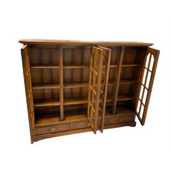 Royal Oak Furniture - oak bookcase with four glazed doors, opening to reveal three fixed shelves, over three drawers 