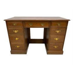 Edwardian walnut kneehole twin pedestal desk, the rectangular top with inset leather writing surface with mahogany crossbanding, central frieze drawer flanked by eight graduating drawers, raised on plinth base
