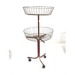 Mid 20th century industrial shop display, with two wirework baskets raised on red painted tubular metal base, H128cm
