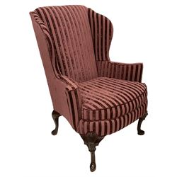 Queen Anne design mahogany framed wingback armchair, upholstered in striped purple fabric with sprung seat and loose seat cushion, raised on cabriole supports with applied shell decoration