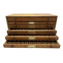 A six drawer printers chest containing a quantity of metal stamps/ matrices and other accessories, H25cm, W50.5cm, D25.5cm
