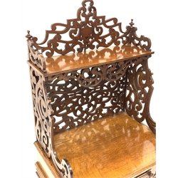 Victorian oak etagere, open shelf raised on scrolled and floral fretwork, over single drawer with blind fretwork embellishment and cushion moulded frieze, raised on octagonal turned supports leading to brass cup castors, W51cm, H114cm, D38cm