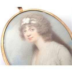Henry Bone RA (British 1755-1834)
Portrait miniature upon ivory, circa 1785
Head and shoulder portrait of Lucia Maria Young, wearing white dress
Signed H Bone
Within gilt frame with blue enamel and hair work panel with seed pearl initial 'L' to centre verso 
Oval 7cm x 6cm

Lucia Maria Young was the eldest daughter of Admiral Sir George Young. Lucia would have been around twenty years old at the time this miniature was painted. 

During his early career, Henry Bone worked as a porcelain and jewellery painter, and exhibited regularly the Royal Academy as an elected Royal Academician. 
He was appointed as Royal Enamelist to King George III, George IV and William IV. 
Due to the quality of his work Bone is said to have been known as the 