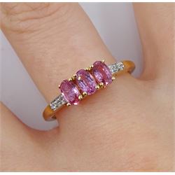 9ct gold three stone oval pink sapphire ring, with white zircon set shoulders, hallmarked, total sapphire weight 0.90 carat